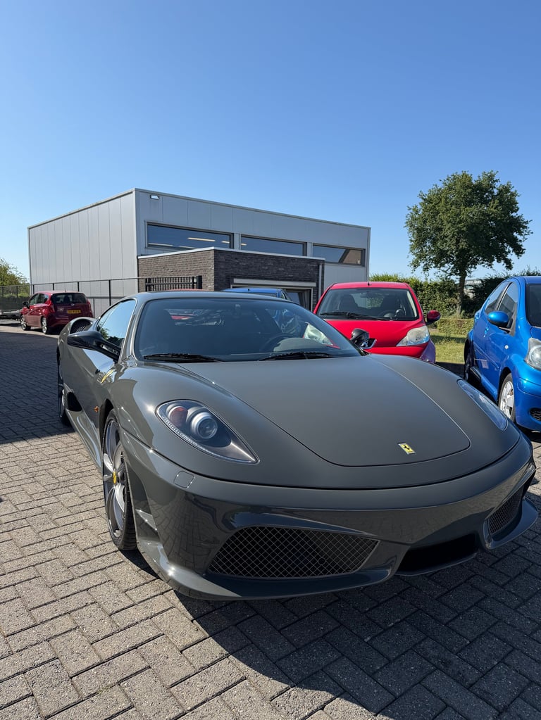 Grey Ferrari sports car parked in front of a modern building